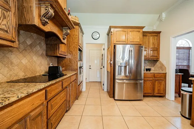 a kitchen with stainless steel appliances granite countertop a refrigerator and a stove top oven