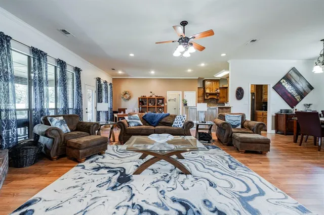 a living room with furniture kitchen view and a large window