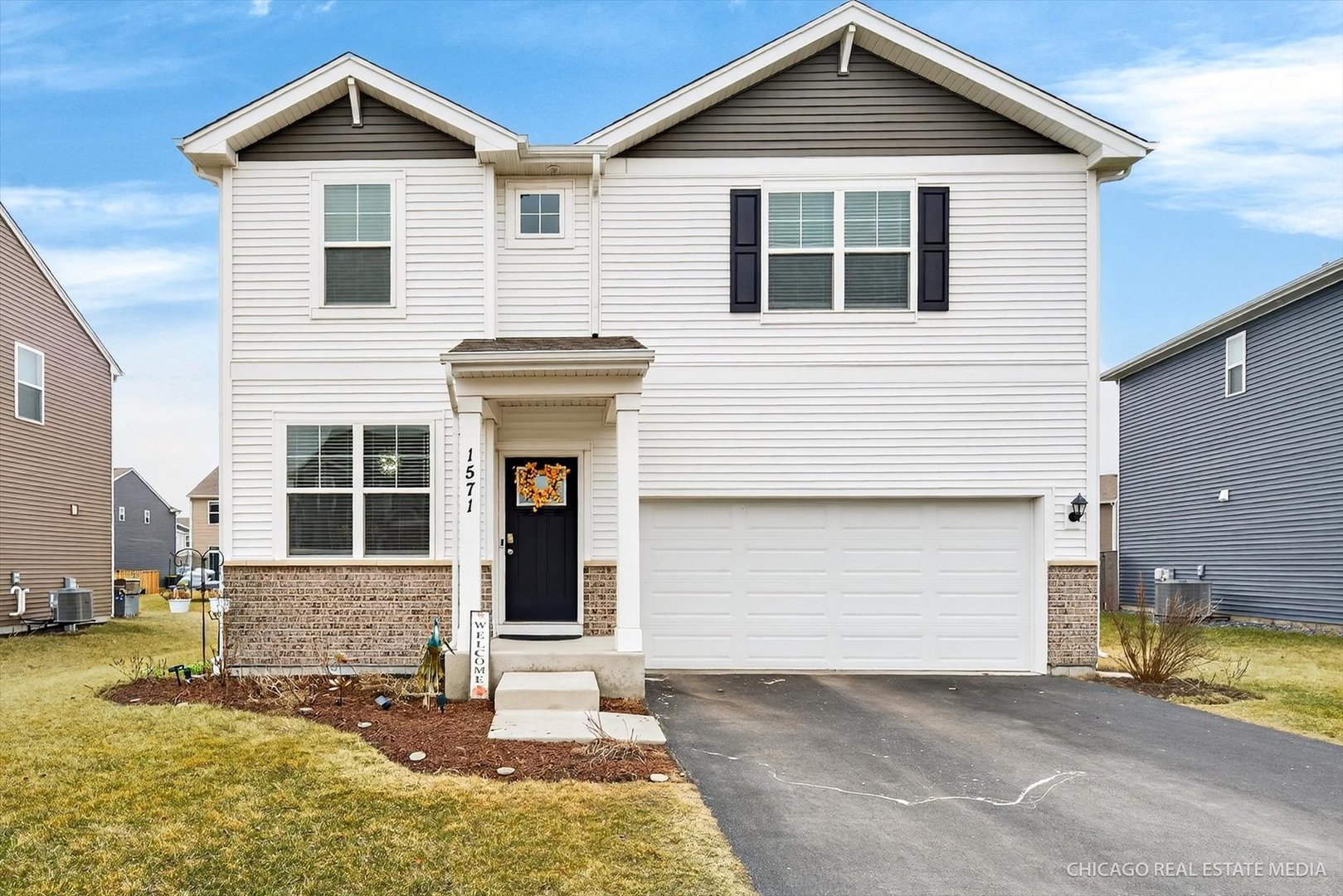 a front view of a house with a yard and garage