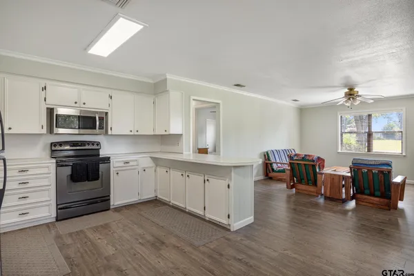 a kitchen with granite countertop white cabinets and stainless steel appliances
