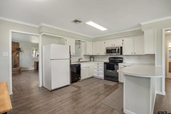 a view of kitchen with stainless steel appliances granite countertop a stove and a refrigerator