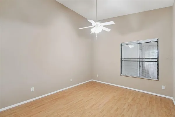 an empty room with windows and fan
