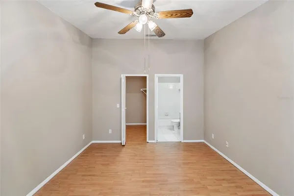 a view of an empty room and chandelier fan