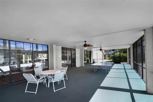 a dining room with furniture and large windows