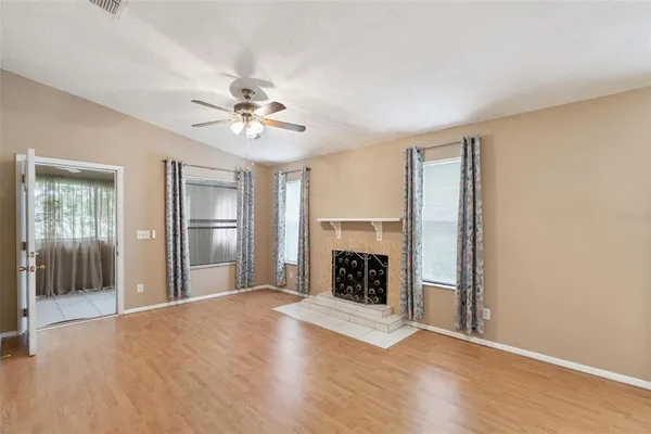 an empty room with fireplace and windows