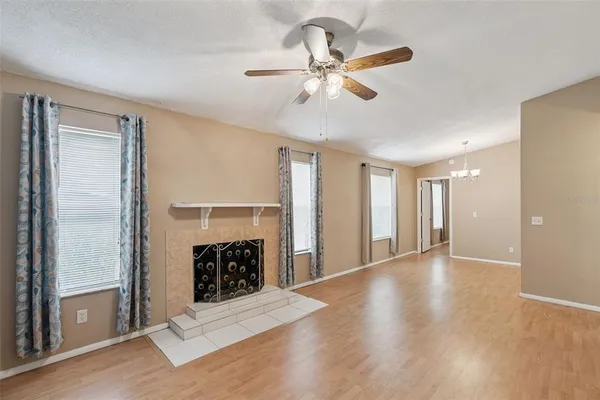 a view of an empty room with a fireplace and a window