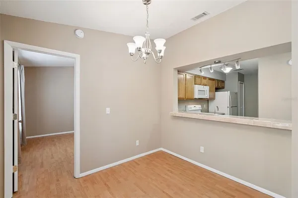 a view of a room with wooden floor and chandelier