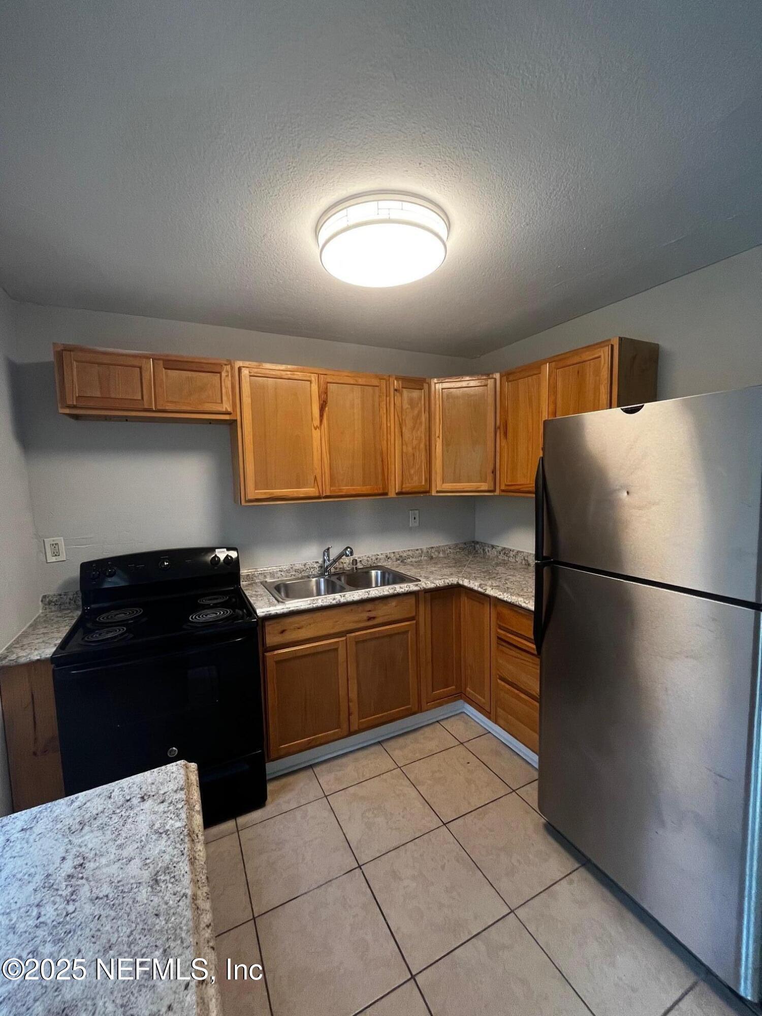 3970 Winton Drive Jacksonville, FL 32208 - Photo 3 of 5 a kitchen with a refrigerator and a stove top oven