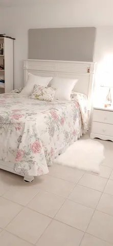 a large white bed sitting in a bedroom