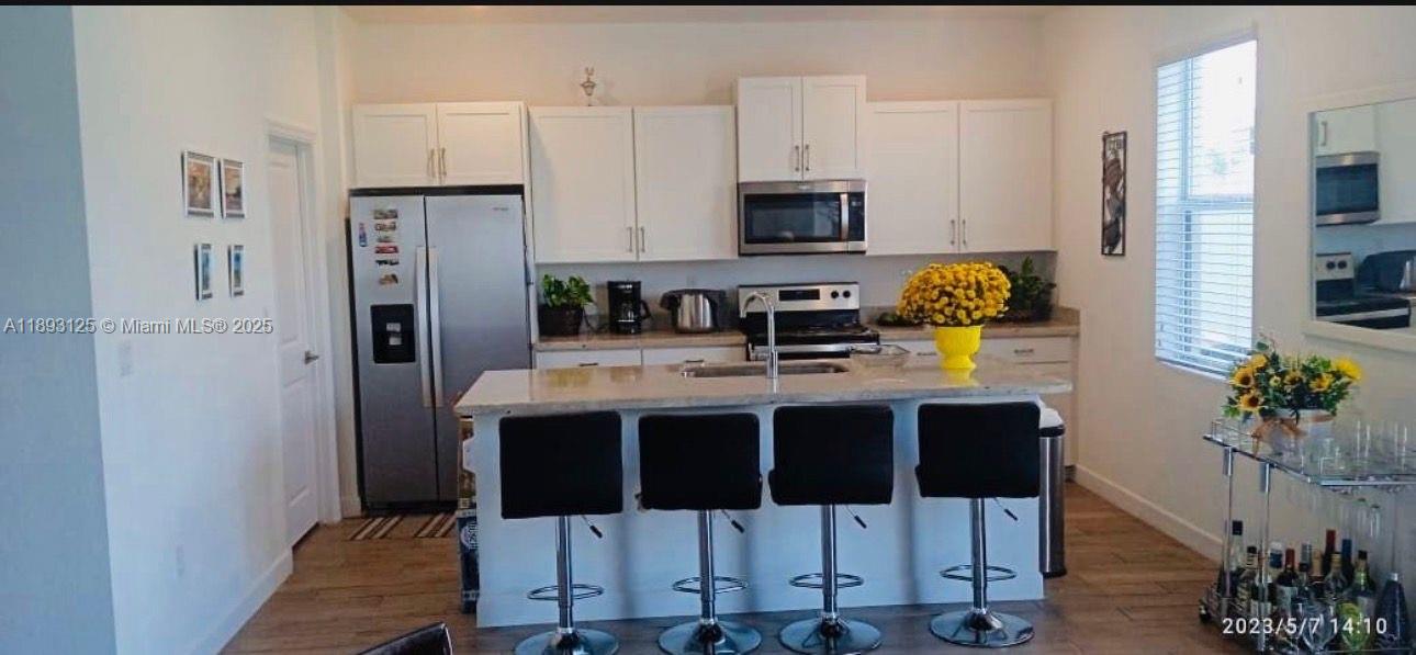 13219 Southwest 270th Terrace Homestead, FL 33032 - Photo 3 of 11 a kitchen with stainless steel appliances kitchen island granite countertop a refrigerator and microwave