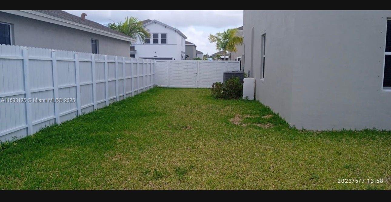 13219 Southwest 270th Terrace Homestead, FL 33032 - Photo 6 of 11 a view of a backyard with potted plants and wooden fence