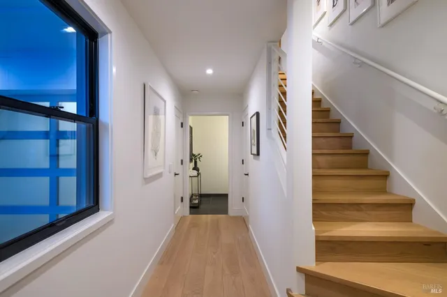 a view of a hallway with wooden floor and entryway