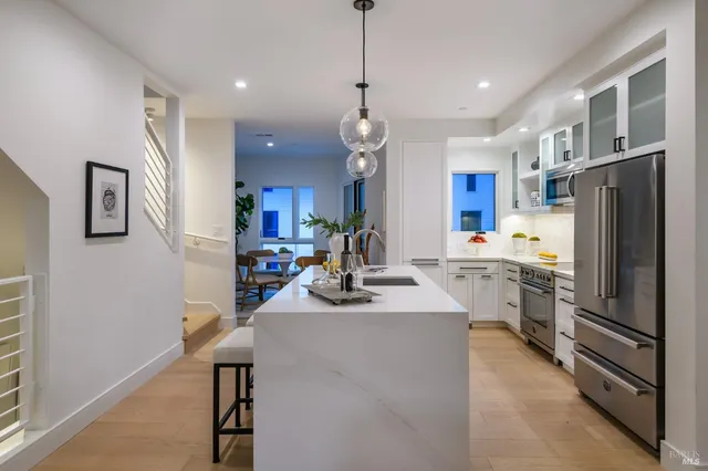 a kitchen that has a lot of cabinets and refrigerator in it