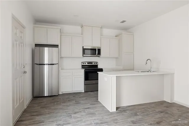 a kitchen with a refrigerator and a sink