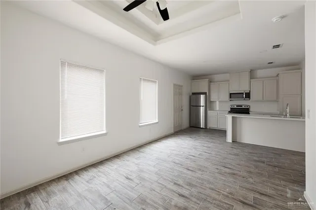 an empty room with a window and a fan