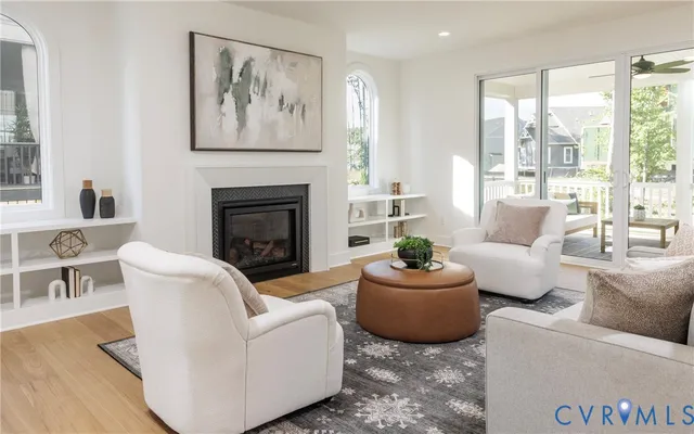 a living room with furniture a fireplace and a large window