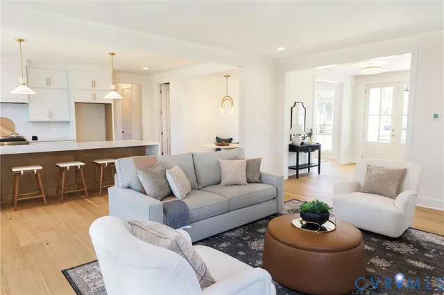 a living room with furniture potted plant and kitchen view