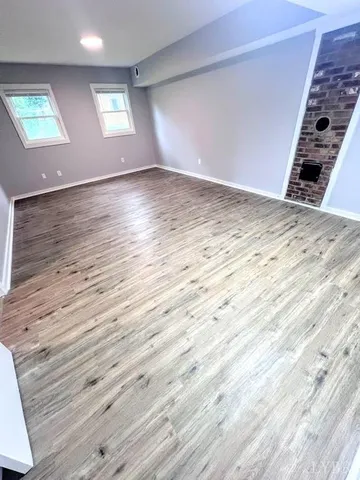 an empty room with wooden floor windows and wooden floor