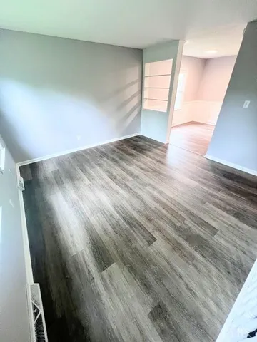 a view of empty room with wooden floor