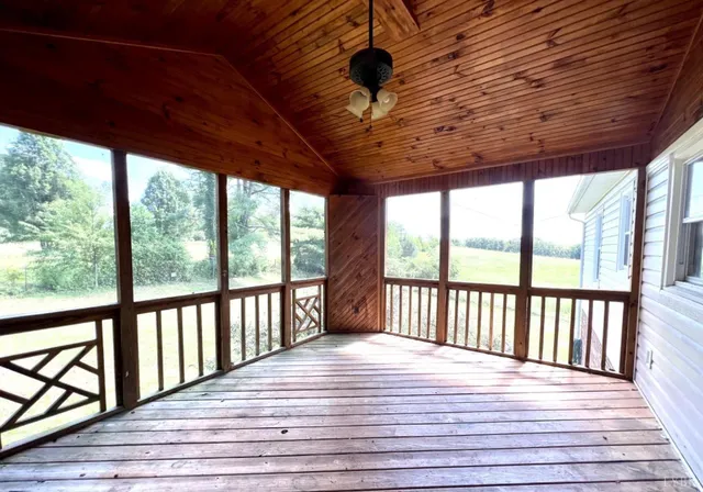 a large white bed sitting in a bedroom next to a window