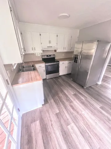 a kitchen with stainless steel appliances granite countertop a sink a stove and a refrigerator