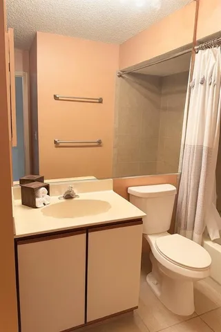 a bathroom with a sink a toilet a mirror and shower