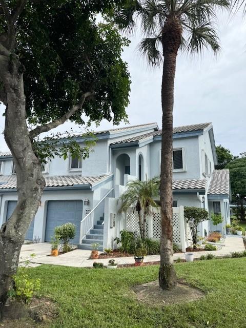 9778 Nickels Boulevard, Unit 504 Boynton Beach, FL 33436 - Photo 3 of 31 a front view of a house with a garden and tree