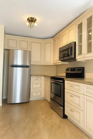 a kitchen with stainless steel appliances granite countertop a refrigerator a stove a microwave and cabinets