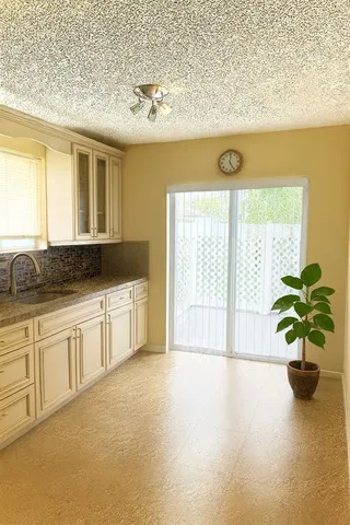 a white kitchen with a stove a sink and a window