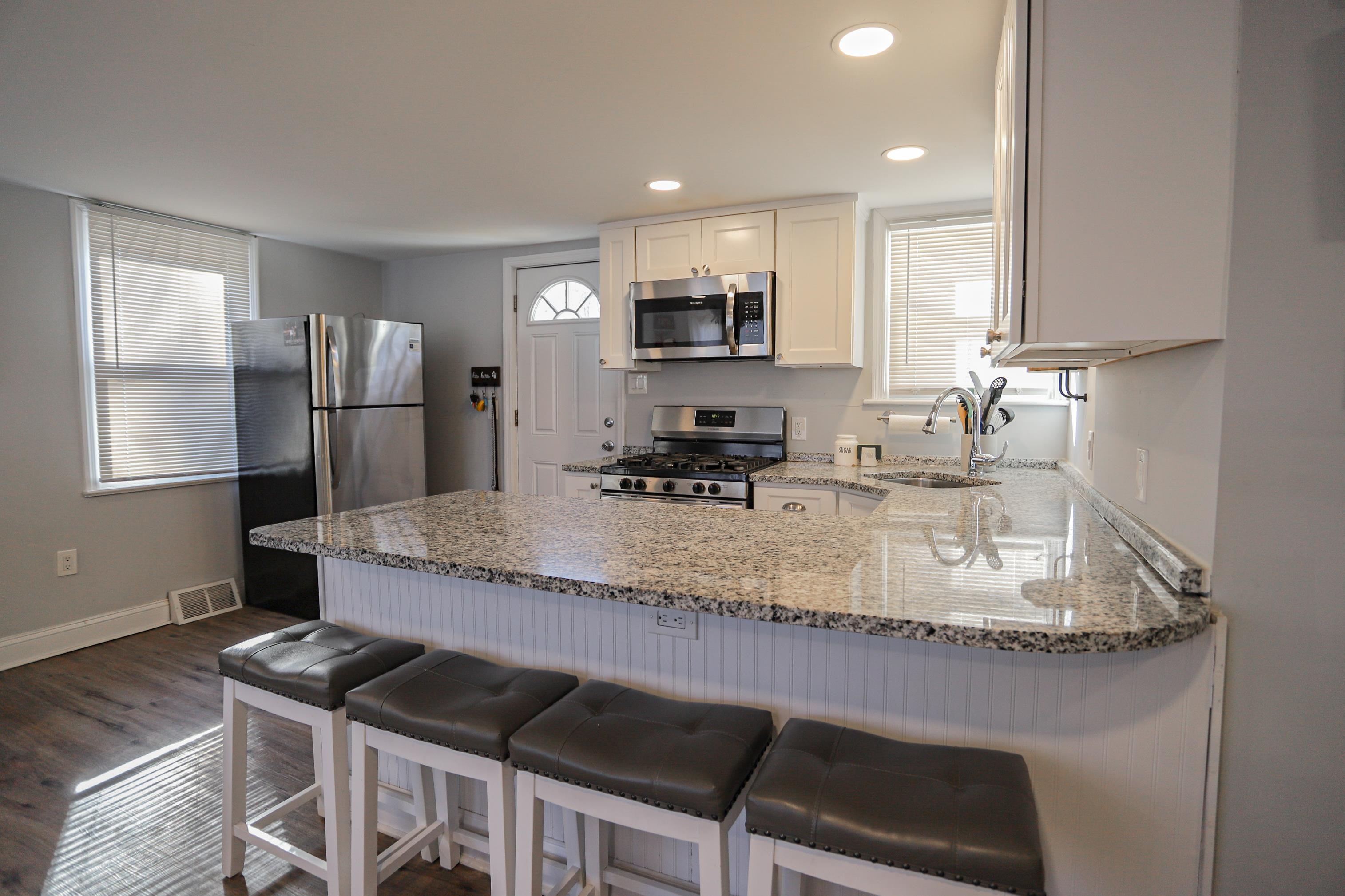 101 Sunset Road Corbin City, NJ 08270 - Photo 7 of 21 a kitchen with kitchen island granite countertop a stove and a refrigerator