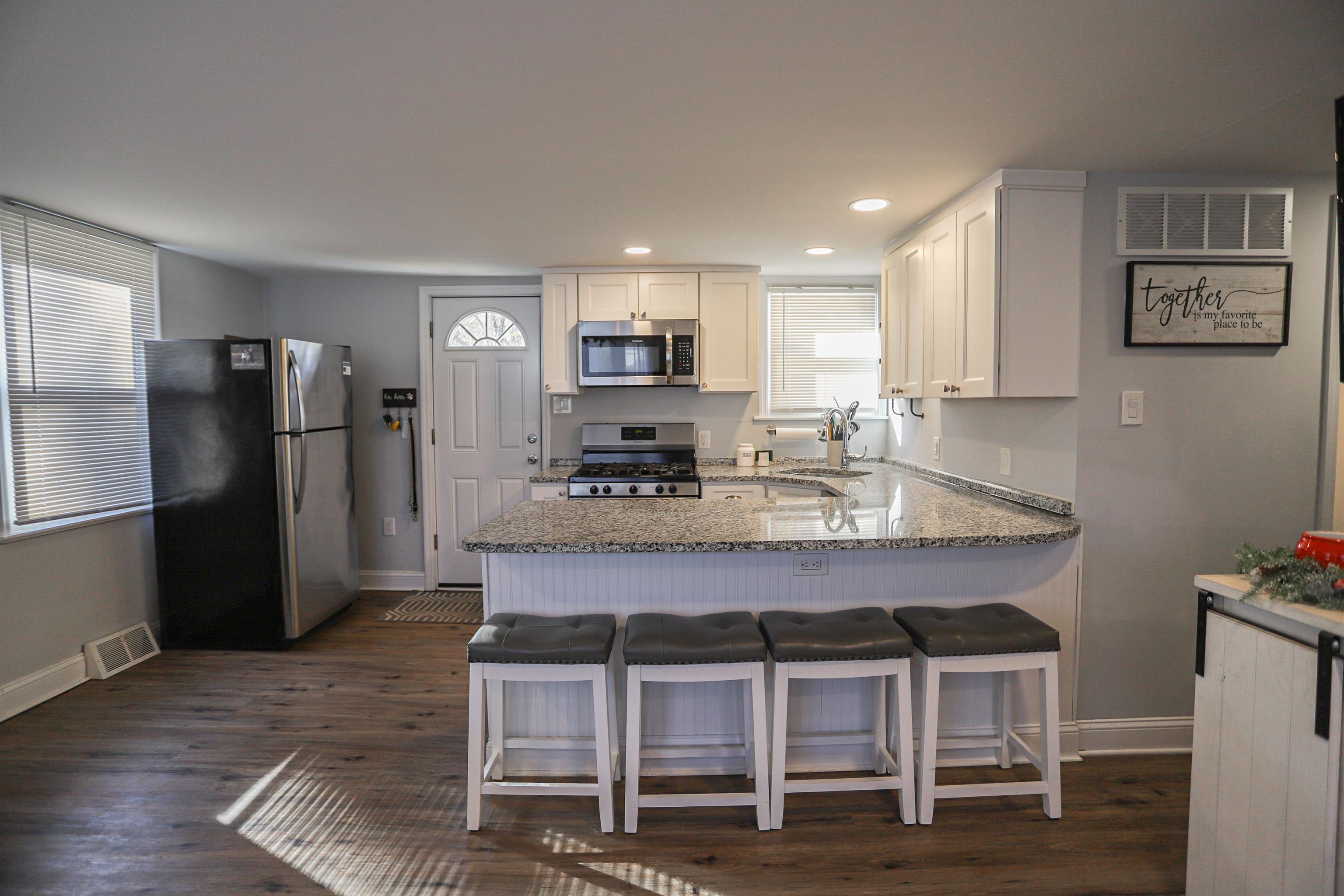 101 Sunset Road Corbin City, NJ 08270 - Photo 10 of 21 a kitchen with a dining table chairs refrigerator and cabinets