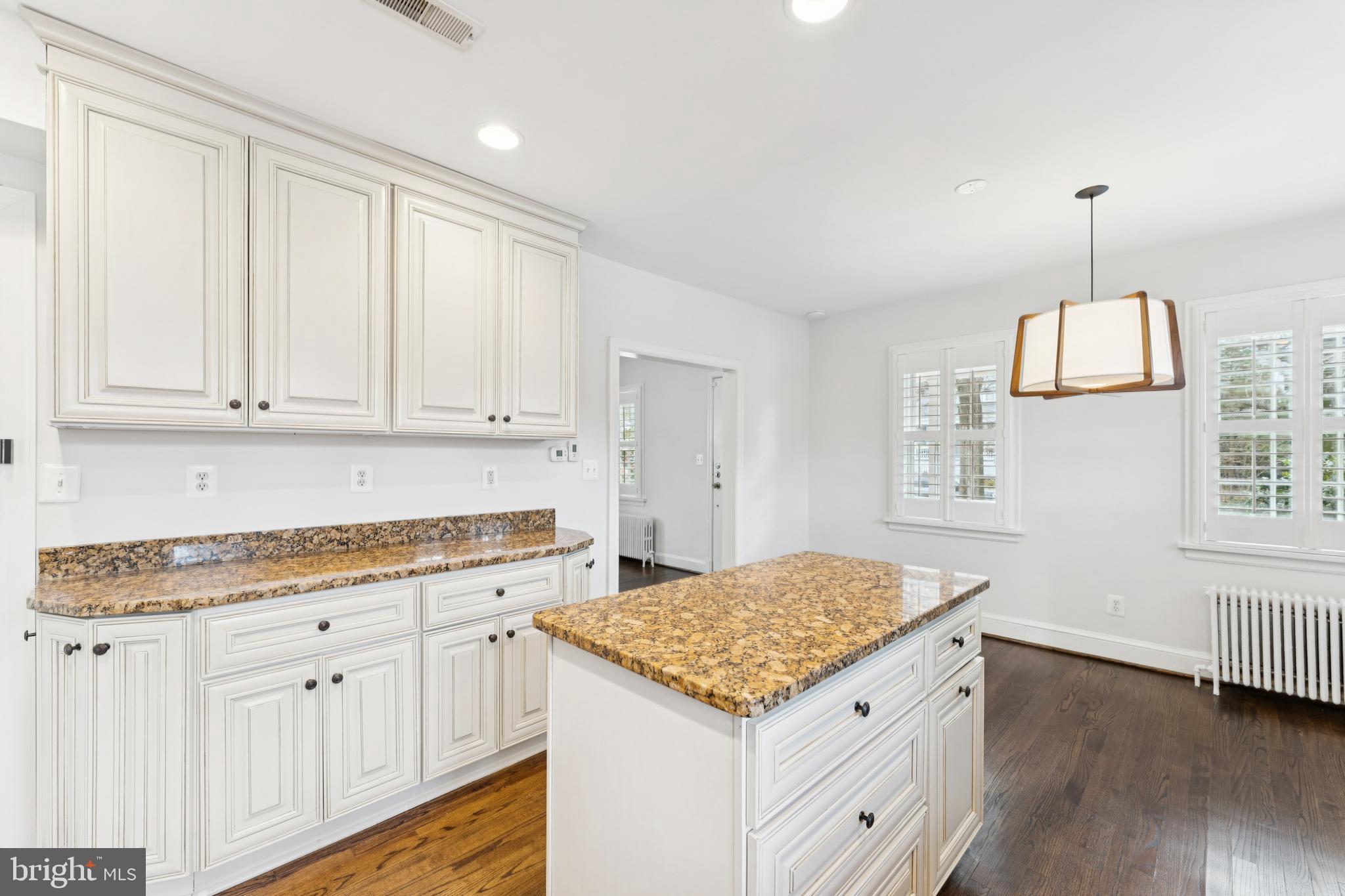 3515 Taylor Street Chevy Chase, MD 20815 - Photo 11 of 40 a kitchen with granite countertop white cabinets and a wooden floor