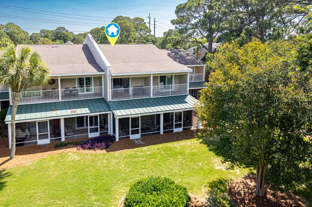 an aerial view of a house with swimming pool and large trees