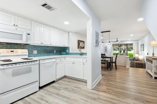 a kitchen with granite countertop cabinets a dining table and stainless steel appliances