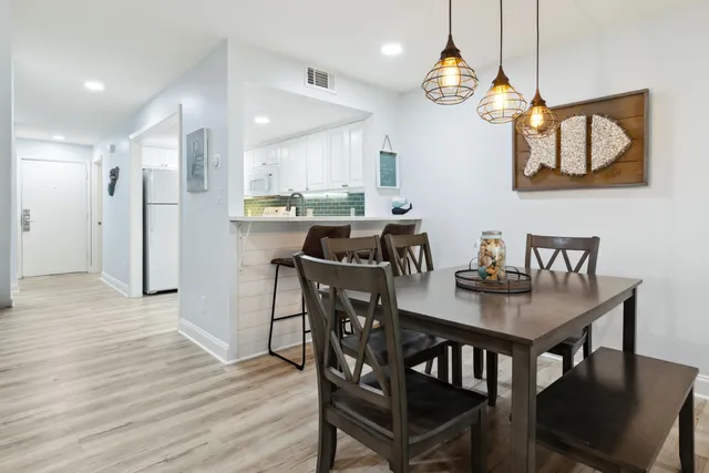 a view of a dining room with furniture a chandelier and wooden floor