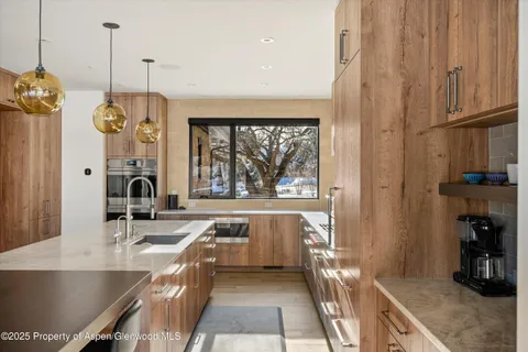 a living room with stainless steel appliances granite countertop furniture a fireplace and a large window