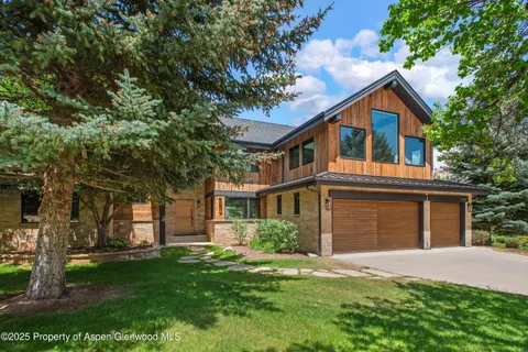 a front view of a house with a garden and yard