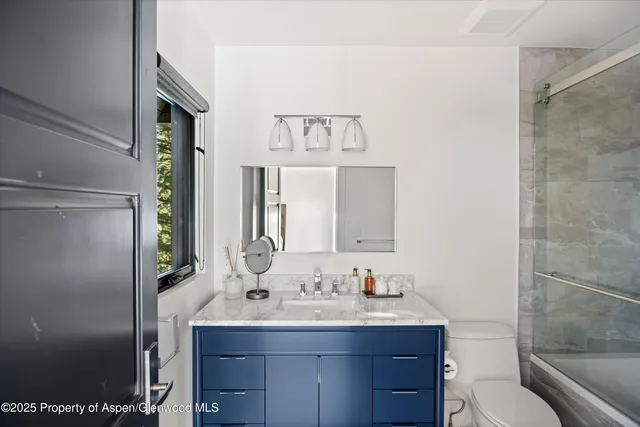 a bedroom with a bed a couch and a window