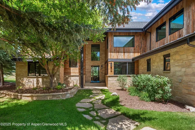 a view of a white house with a big yard and potted plants