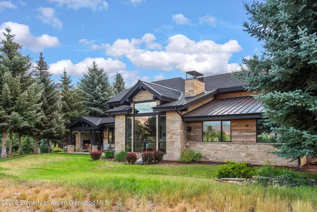 a front view of a house with yard and trees