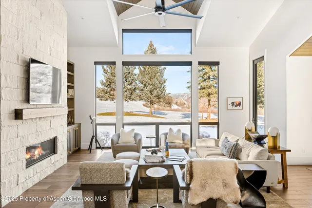 a living room with fireplace furniture and a large window