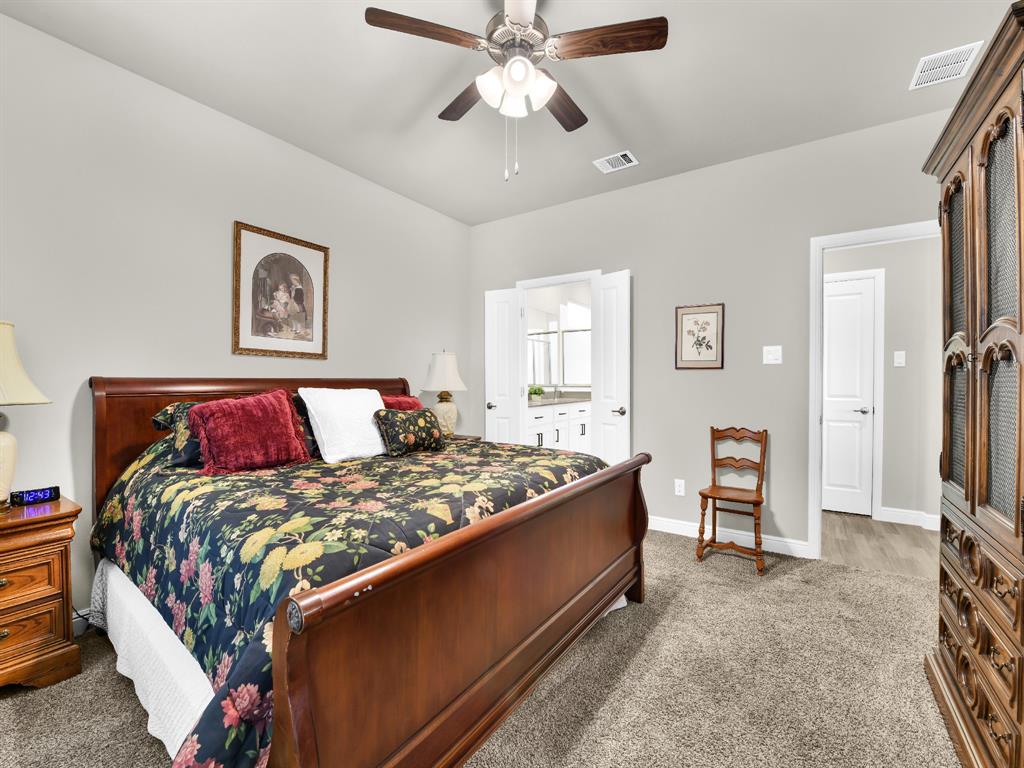 2364 Waggoner Rnch Drive Weatherford, TX 76087 - Photo 18 of 30 a bedroom with a bed and a chandelier