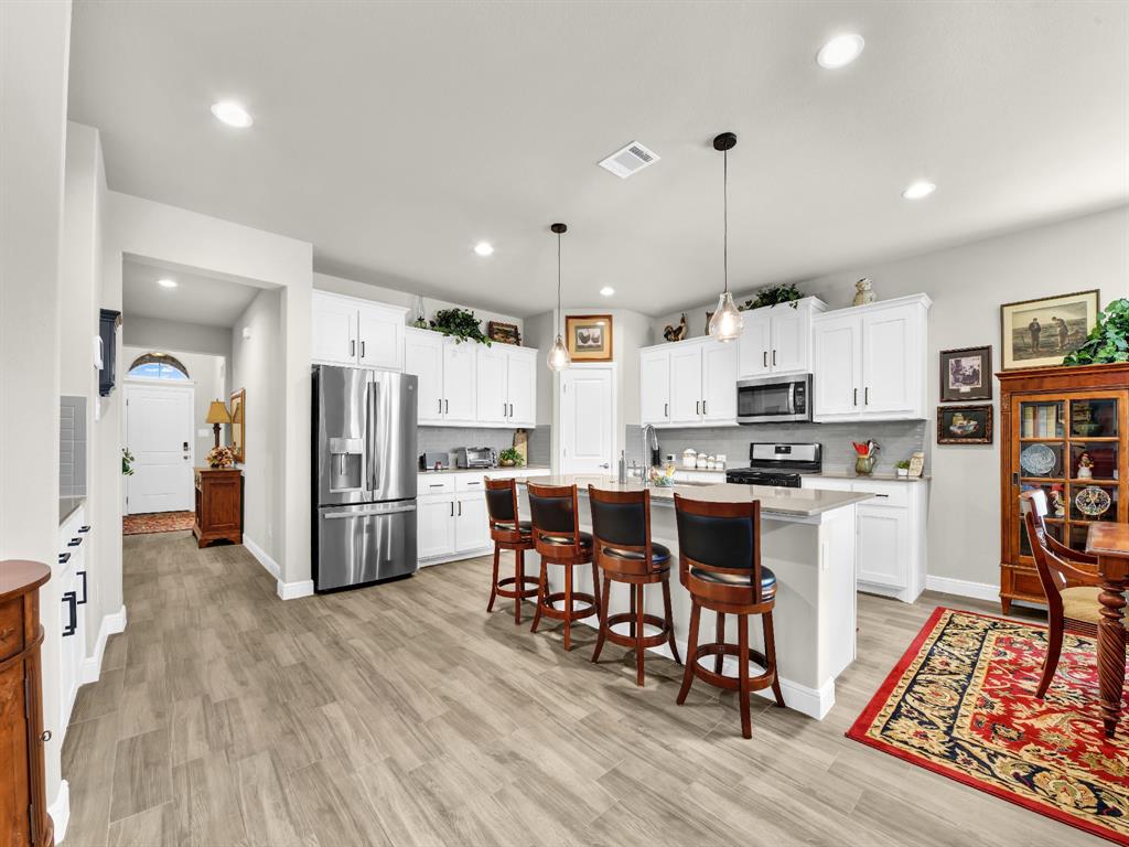 2364 Waggoner Rnch Drive Weatherford, TX 76087 - Photo 9 of 30 a kitchen with stainless steel appliances a refrigerator sink and wooden floor