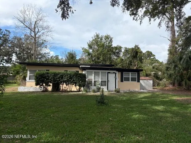 a front view of a house with a yard and trees