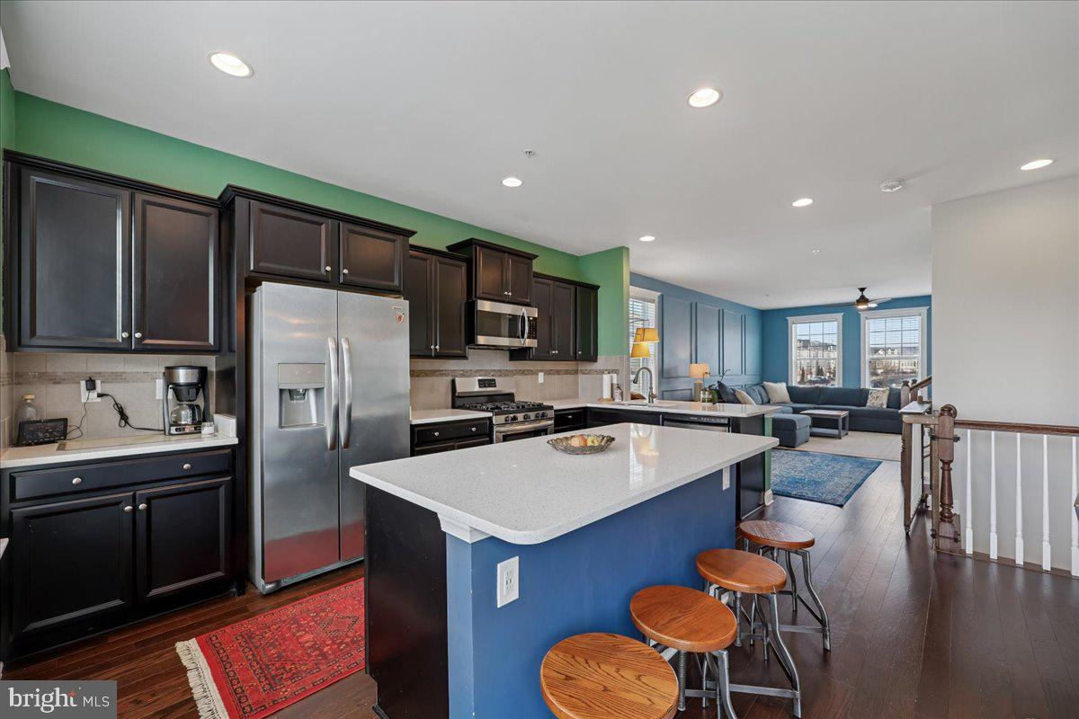 6501 Britannic Place Frederick, MD 21703 - Photo 18 of 64 a kitchen with a refrigerator a stove top oven a sink dishwasher and white cabinets with wooden floor