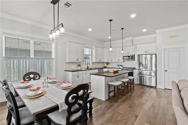 a kitchen that has a lot of cabinets a sink and appliances