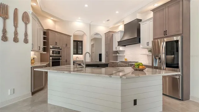 a kitchen with stainless steel appliances granite countertop a stove top oven a sink dishwasher and cabinets with wooden floor