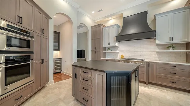 a kitchen with granite countertop a sink stove and refrigerator