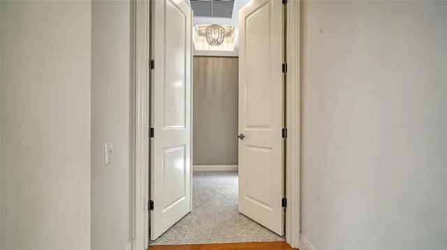 an empty room with chandelier fan and windows