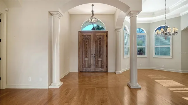 a view of an empty room with window and wooden floor